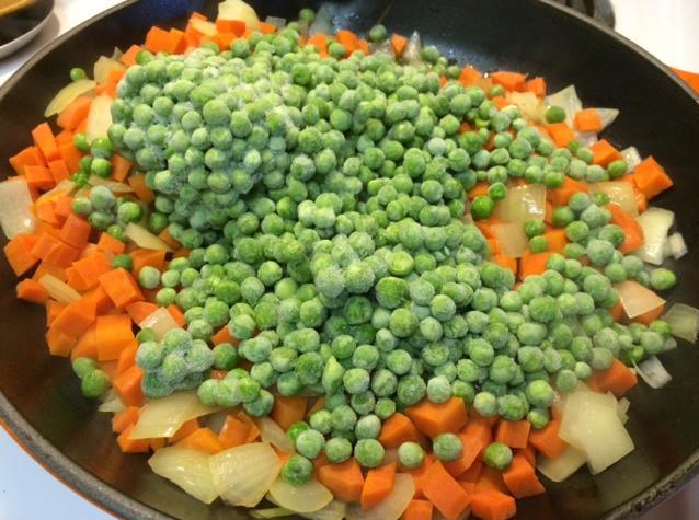 sauteeing carrots peas & onion